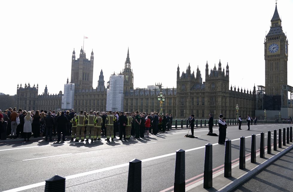 People attend a ceremony on Westminster Bridge in London