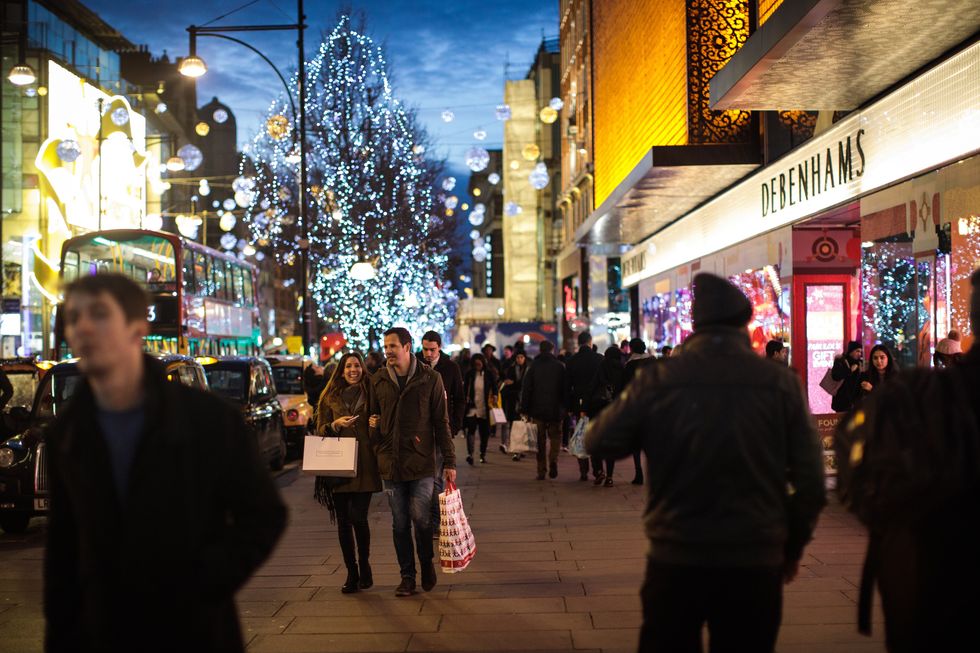 People carry shopping bags along Oxford Street