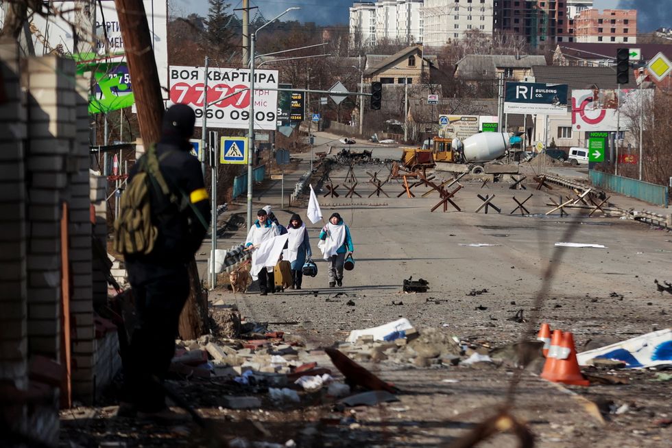 People carry white flags as they walk through the city of Irpin, amid Russia's invasion of Ukraine, in Irpin, Ukraine March 11, 2022. REUTERS/Serhii Nuzhnenko