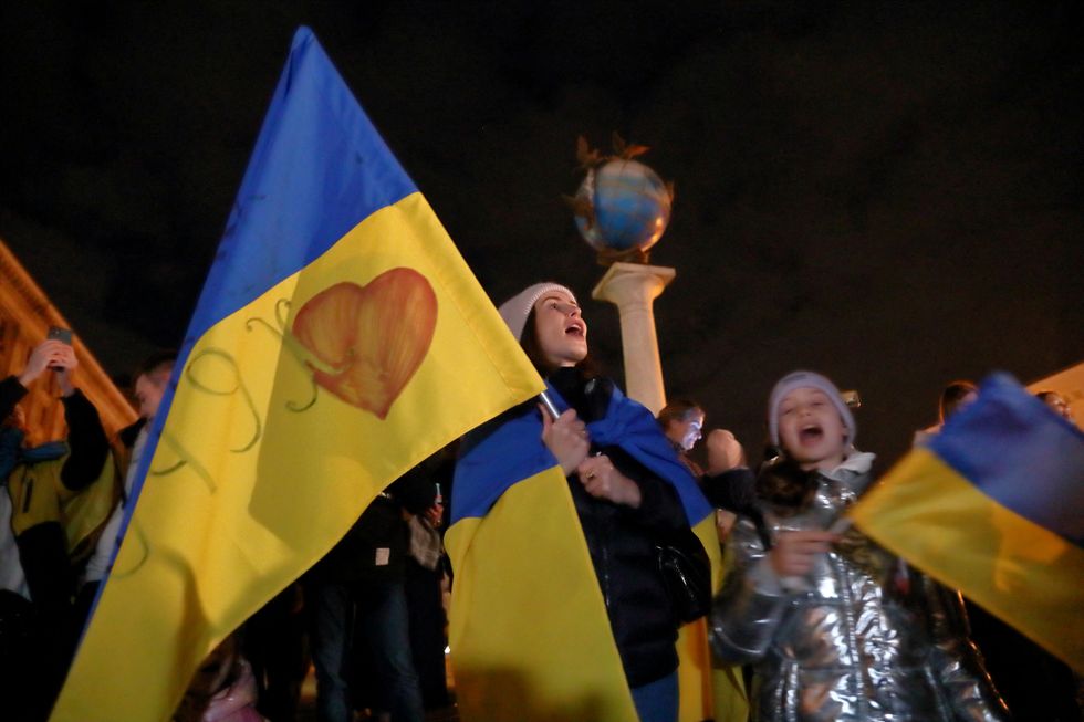 People celebrate after Russia's retreat from Kherson, in central Kyiv, Ukraine.