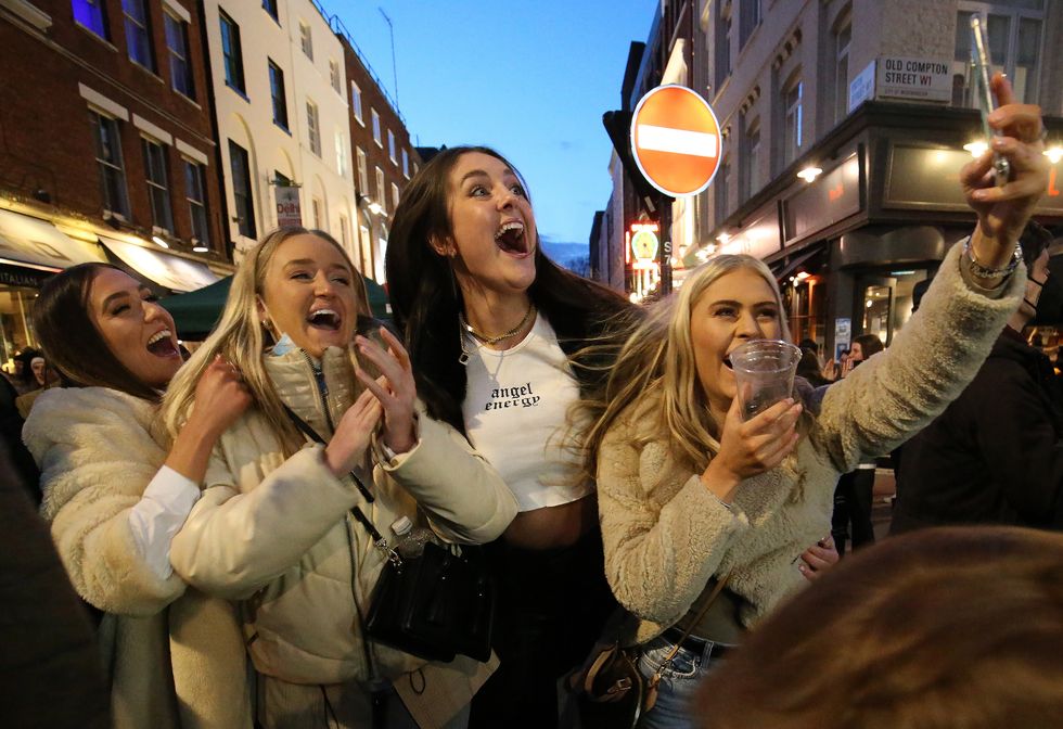 People celebrate being out for the evening in Old Compton Street, Soho, central London, where streets have been closed to traffic to create outdoor seating areas for the reopening bars and restaurants as England takes another step back towards normality with the further easing of lockdown restrictions. Picture date: Monday April 12, 2021.