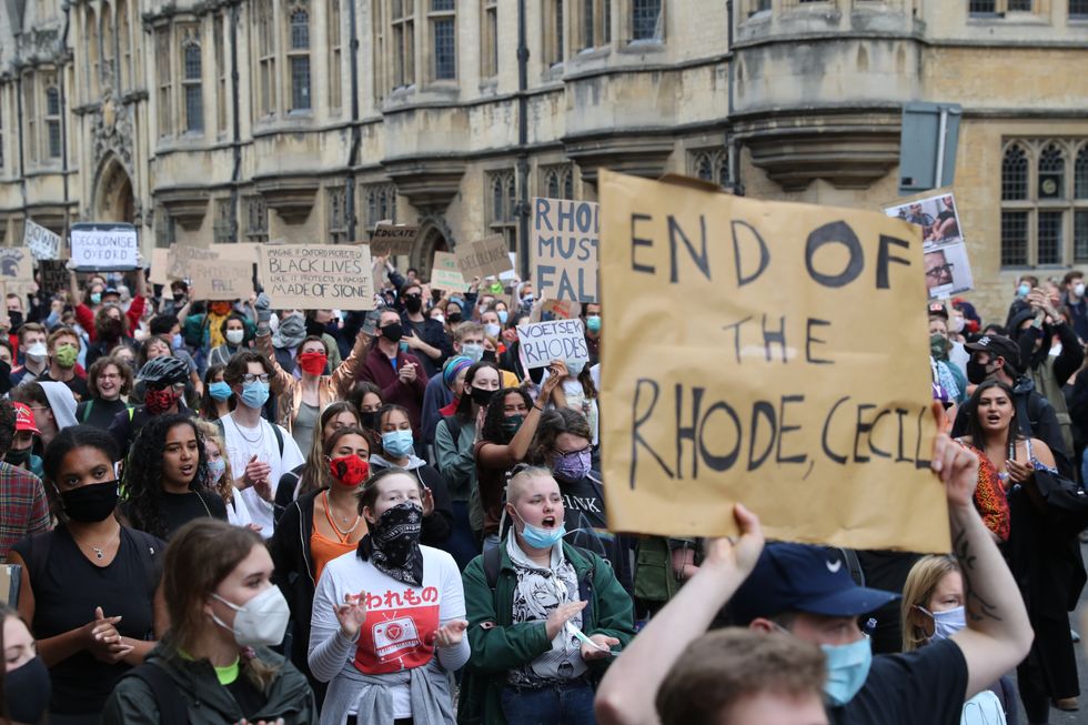 People during a protest calling for the removal of the statue of 19th century imperialist, politician Cecil Rhodes from an Oxford college which has reignited amid anti-racism demonstrations.