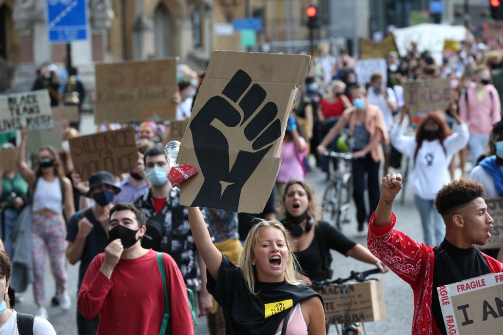 People during Black Lives Matter rally walk along Victoria Street in London.