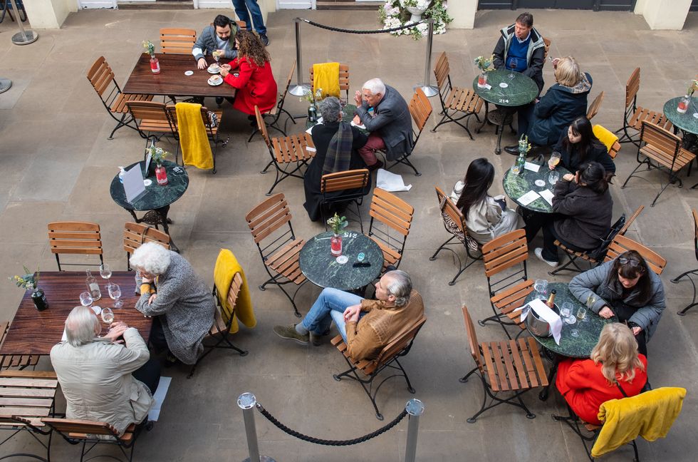 People eat and drink outside a restaurant in Covent Garden Market, London, following the further easing of lockdown restrictions.