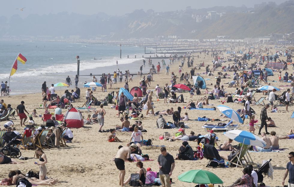 People enjoy the good weather at Bournemouth Beach in Dorset as the UK