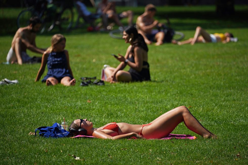 People enjoy the hot weather in St James's Park, London.