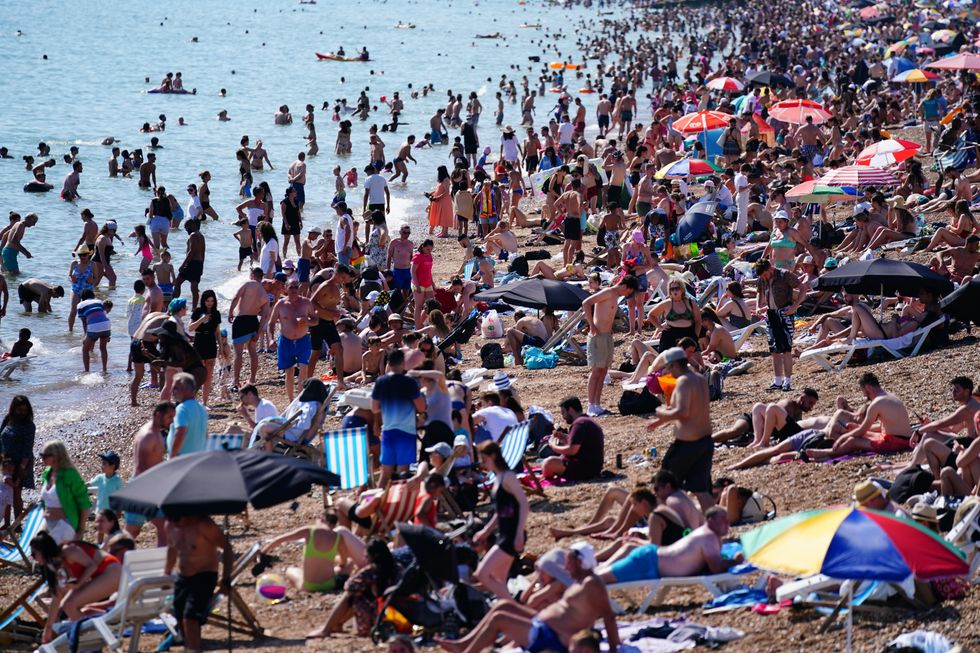 People enjoy the hot weather on Brighton beach in East Sussex. The hottest day of the year so far was recorded in all four UK nations on Saturday and forecasters believe it could be even warmer on Sunday. Picture date: Sunday July 18, 2021.