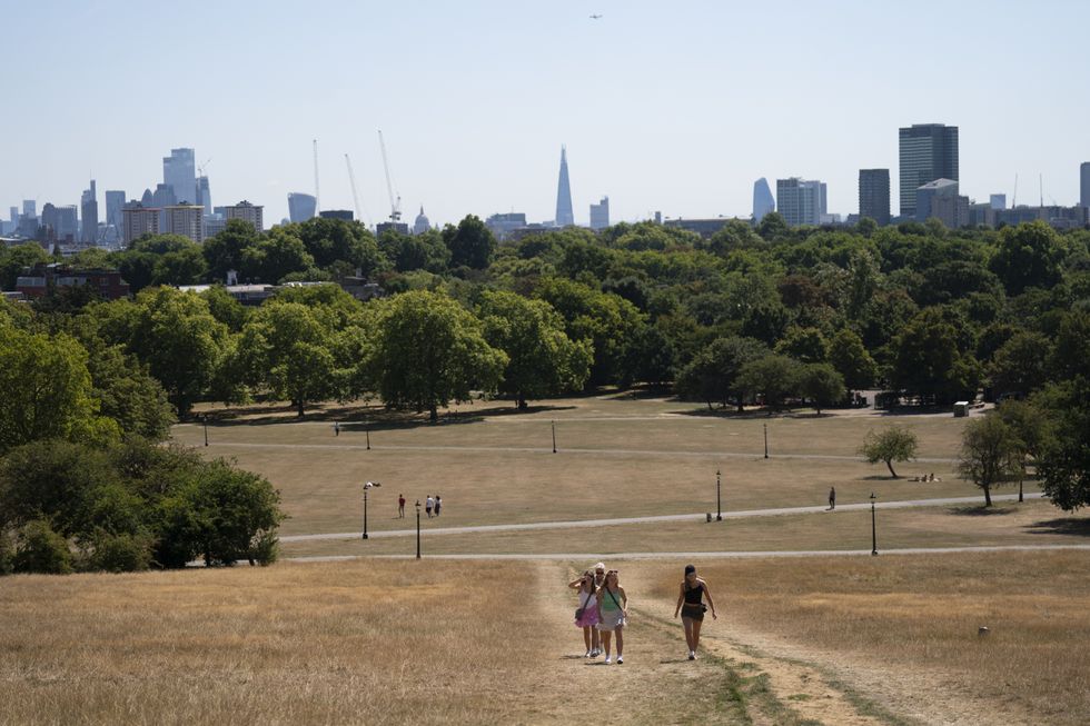 People enjoy the hot weather on Primrose Hill in London where the grass is dry due to lack of water. The Met Office has issued an amber warning for extreme heat covering four days from Thursday to Sunday for parts of England and Wales as a new heatwave looms. Picture date: Tuesday August 9, 2022.