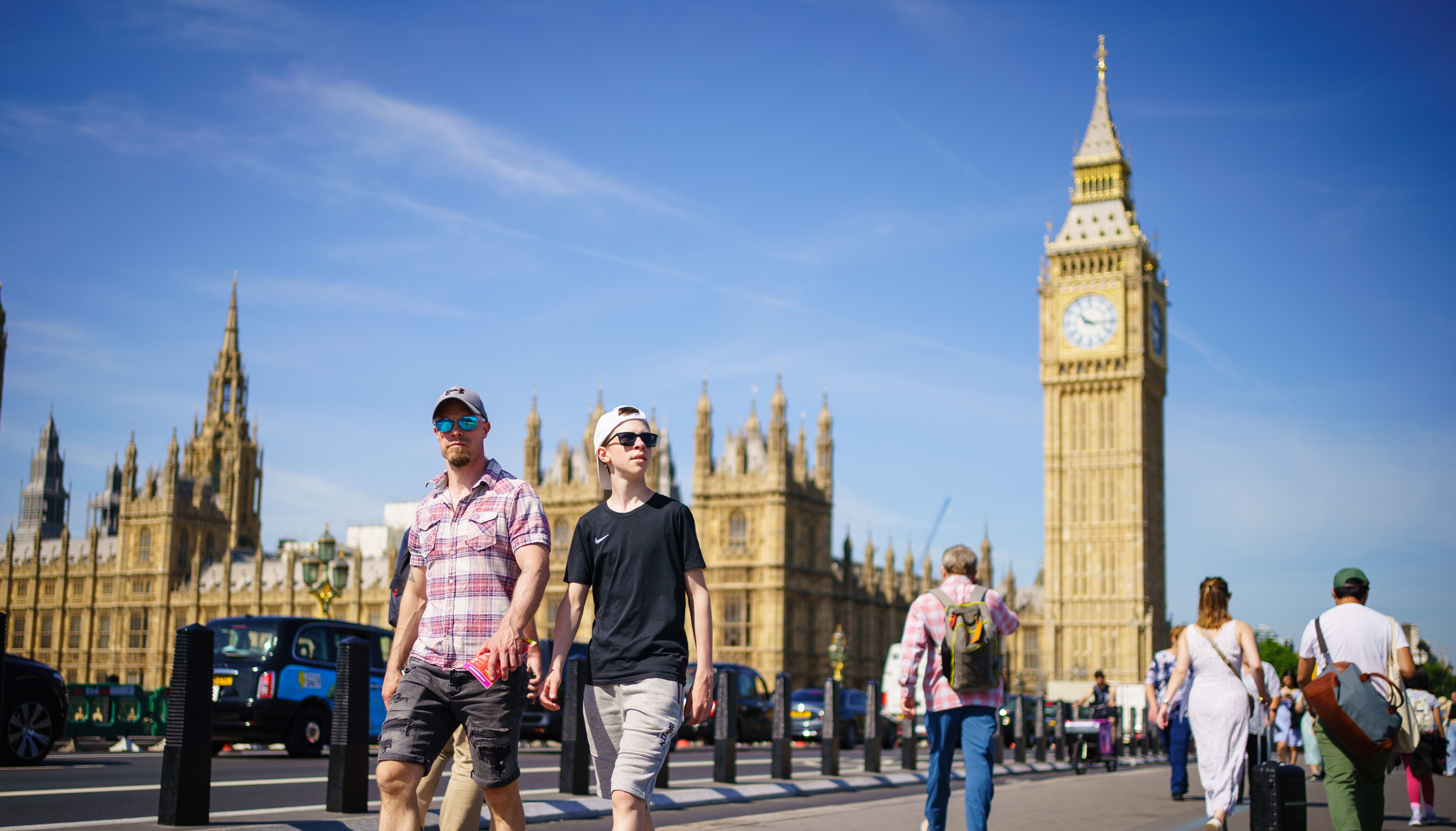 People enjoy the sunny weather on Westminster Bridge, by the Houses of Parliament, London. Picture date: Wednesday June 15, 2022.