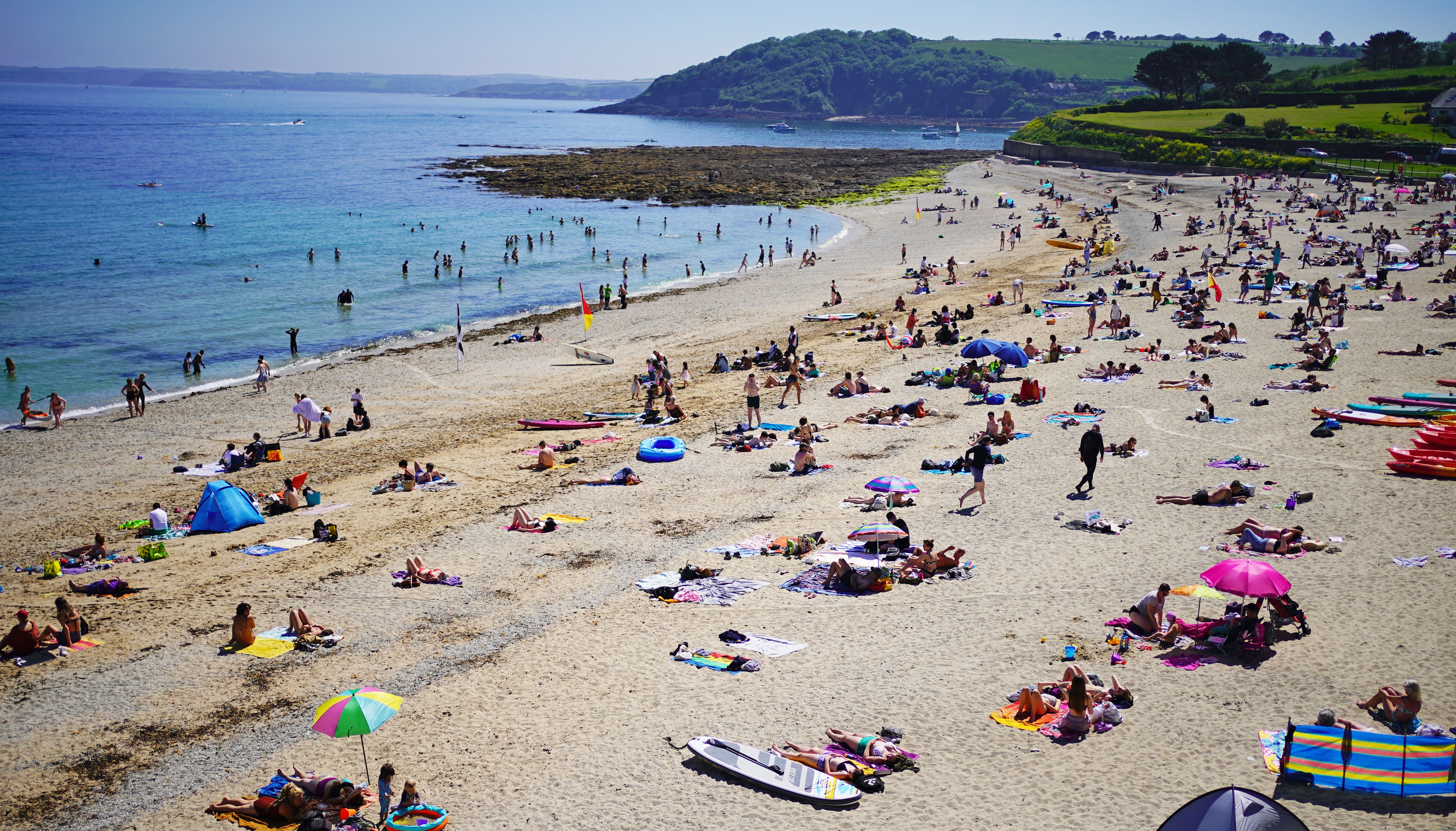 People enjoy the sunshine on Gyllyngvase Beach near Falmouth in Cornwall.