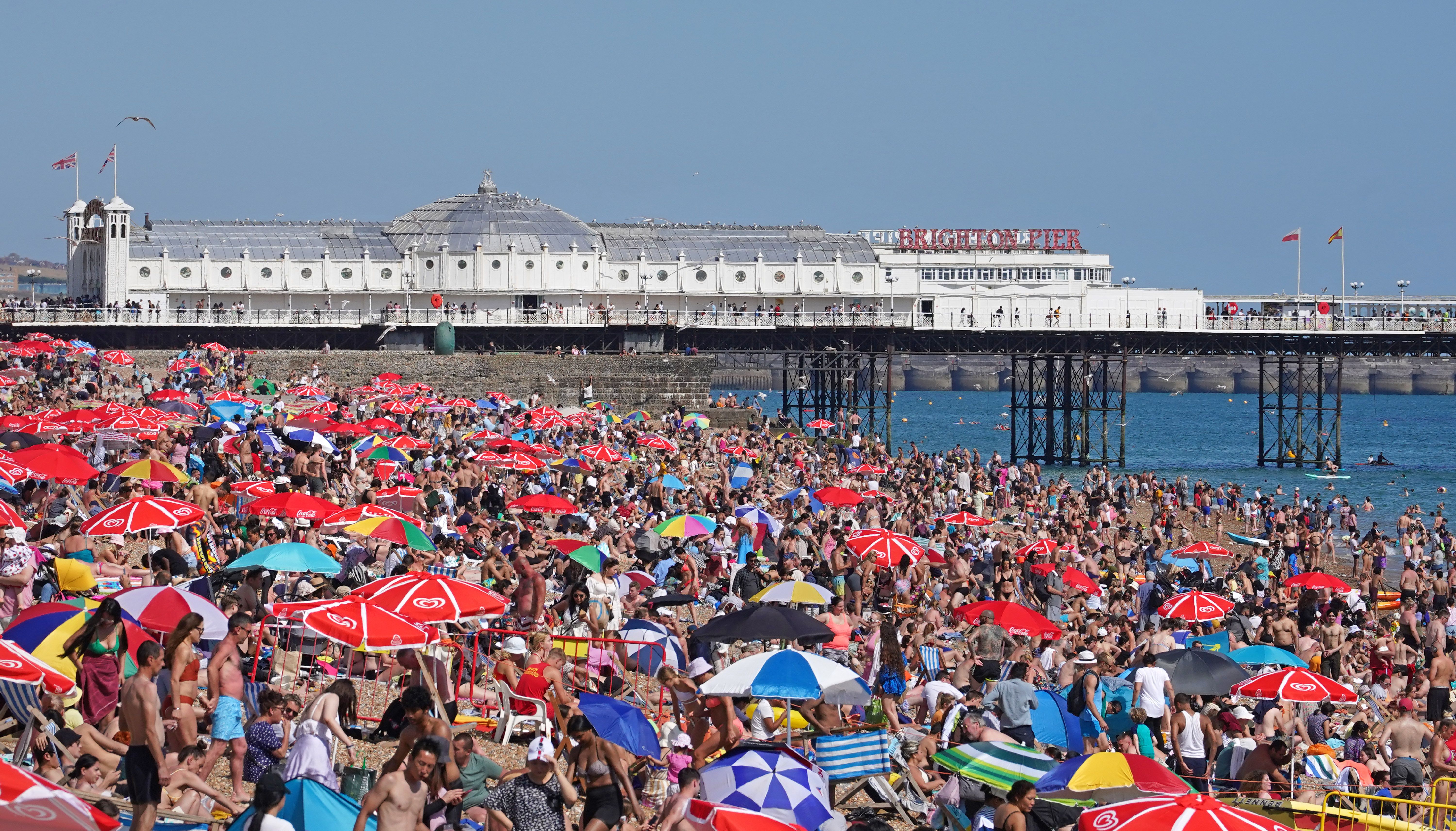 People enjoy the warm weather at Brighton beach in West Sussex. Picture date: Sunday July 10, 2022.