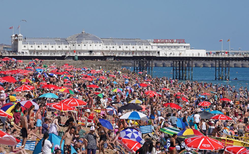 People enjoy the warm weather at Brighton beach in West Sussex. Picture date: Sunday July 10, 2022.