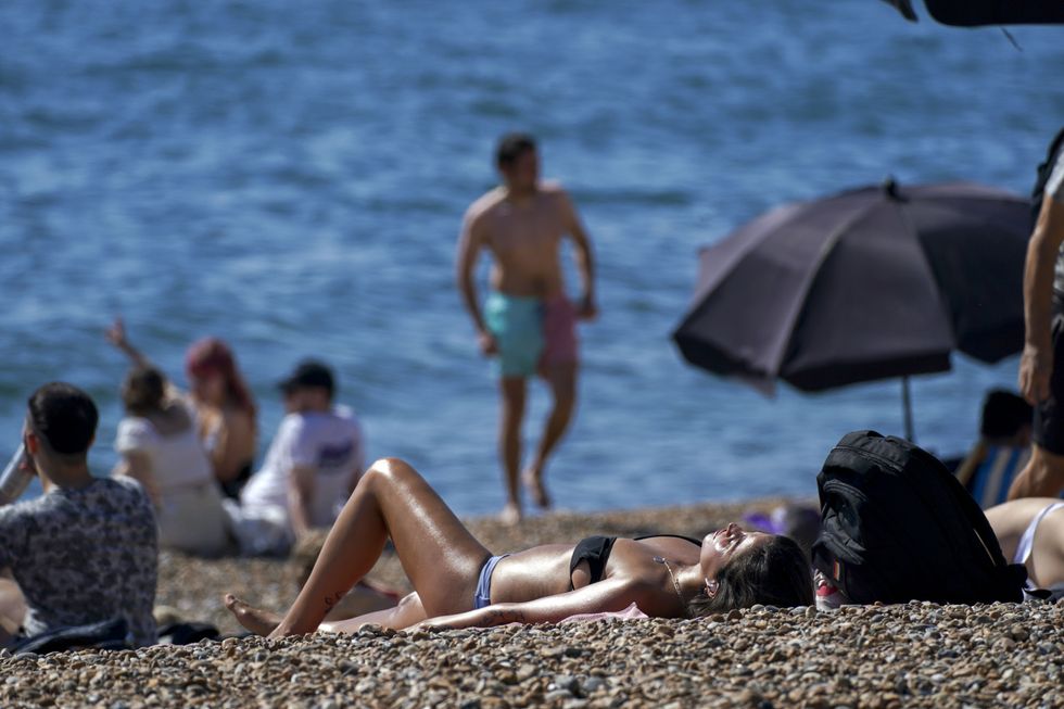People enjoy the warm weather at Brighton beach in West Sussex. Temperatures are forecast to reach up to 30C in parts of the UK on Tuesday as the country enjoys a warm start to September. Picture date: Tuesday September 7, 2021.