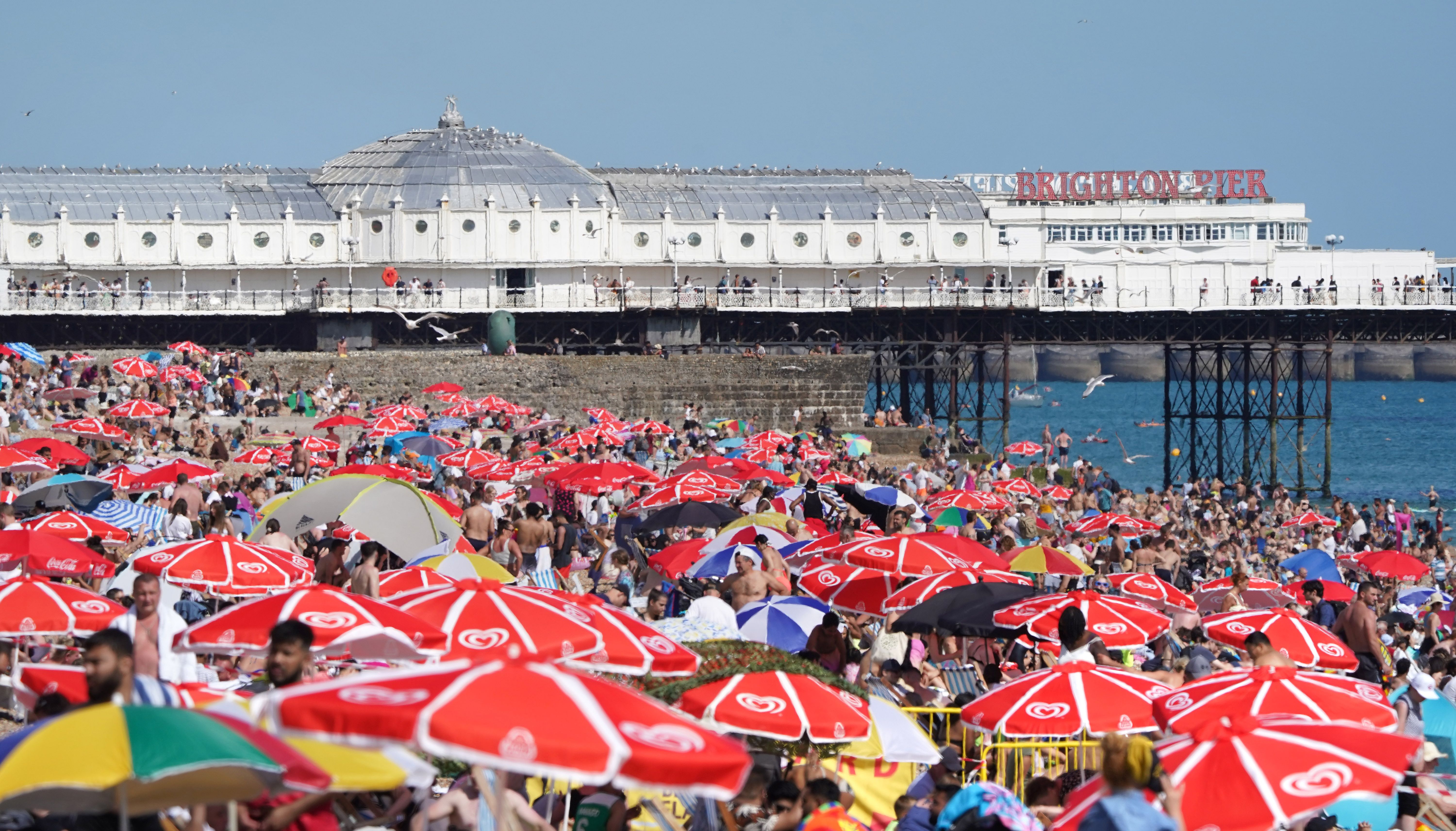 People enjoy the warm weather at Brighton beach in West Sussex.