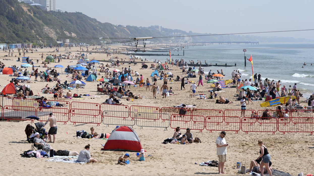 People enjoying the sunny weather on Bournemouth Beach in Dorset