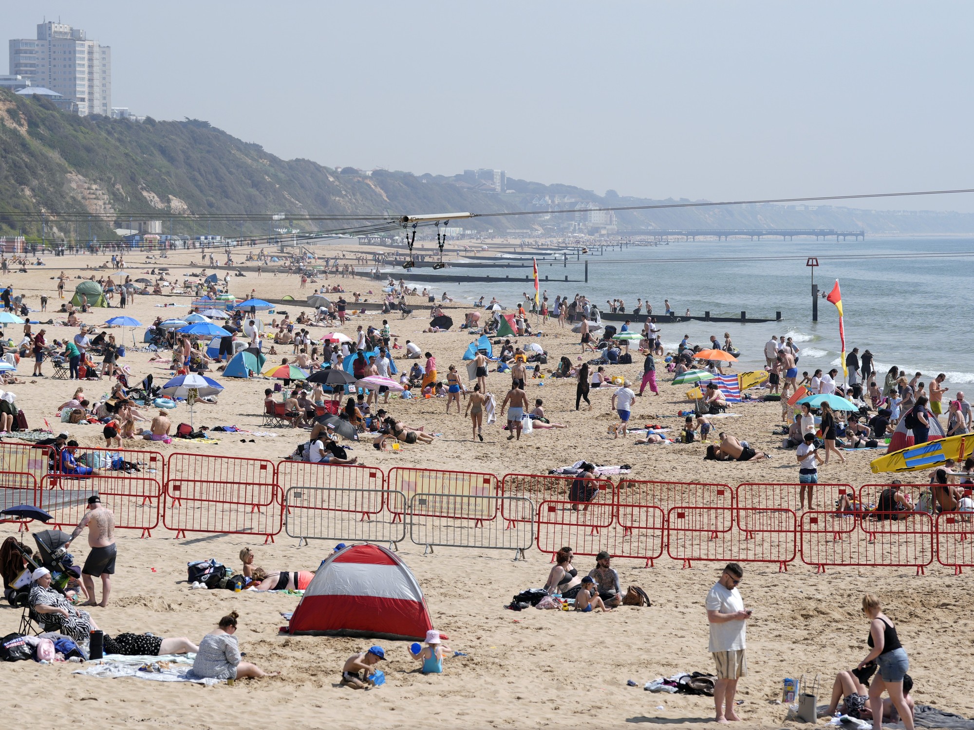 People enjoying the sunny weather on Bournemouth Beach in Dorset