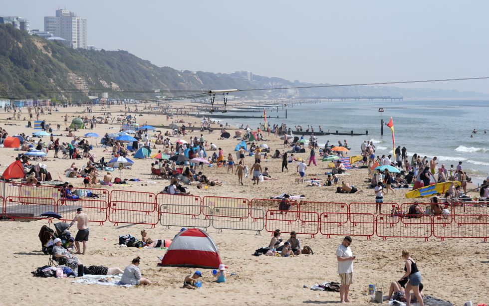 People enjoying the sunny weather on Bournemouth Beach in Dorset