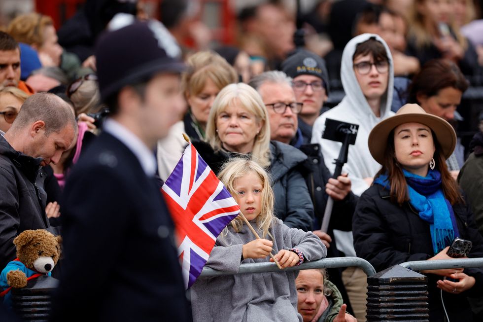 People gather, on the day of the state funeral and burial of Britain's Queen Elizabeth, at Parliament Square in London, Britain, September 19, 2022. REUTERS/Sarah Meyssonnier/Pool