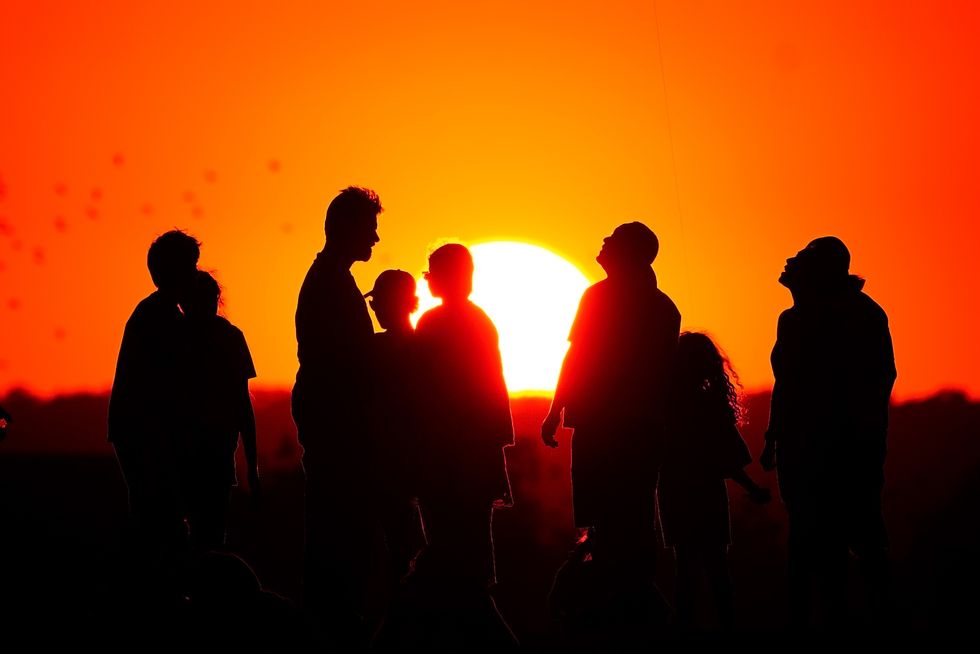 People in front of a sunset
