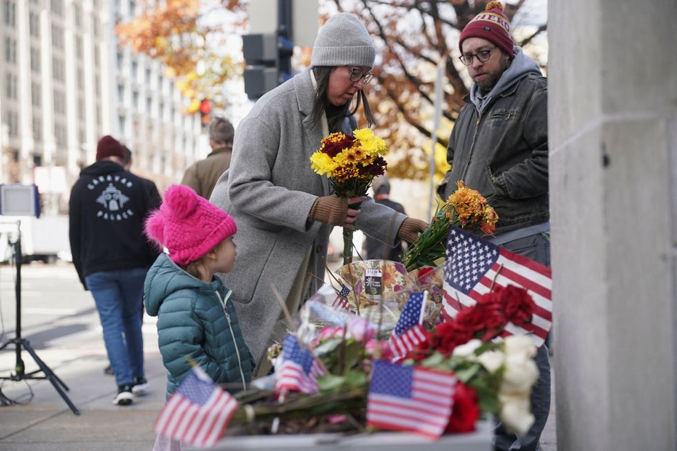 People laying flowers at the site of where two National Guard members were shot in DC