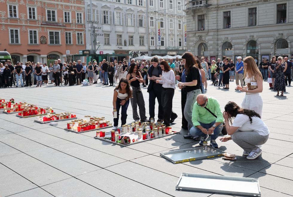 People light candles in Graz's main square after the deadly shooting