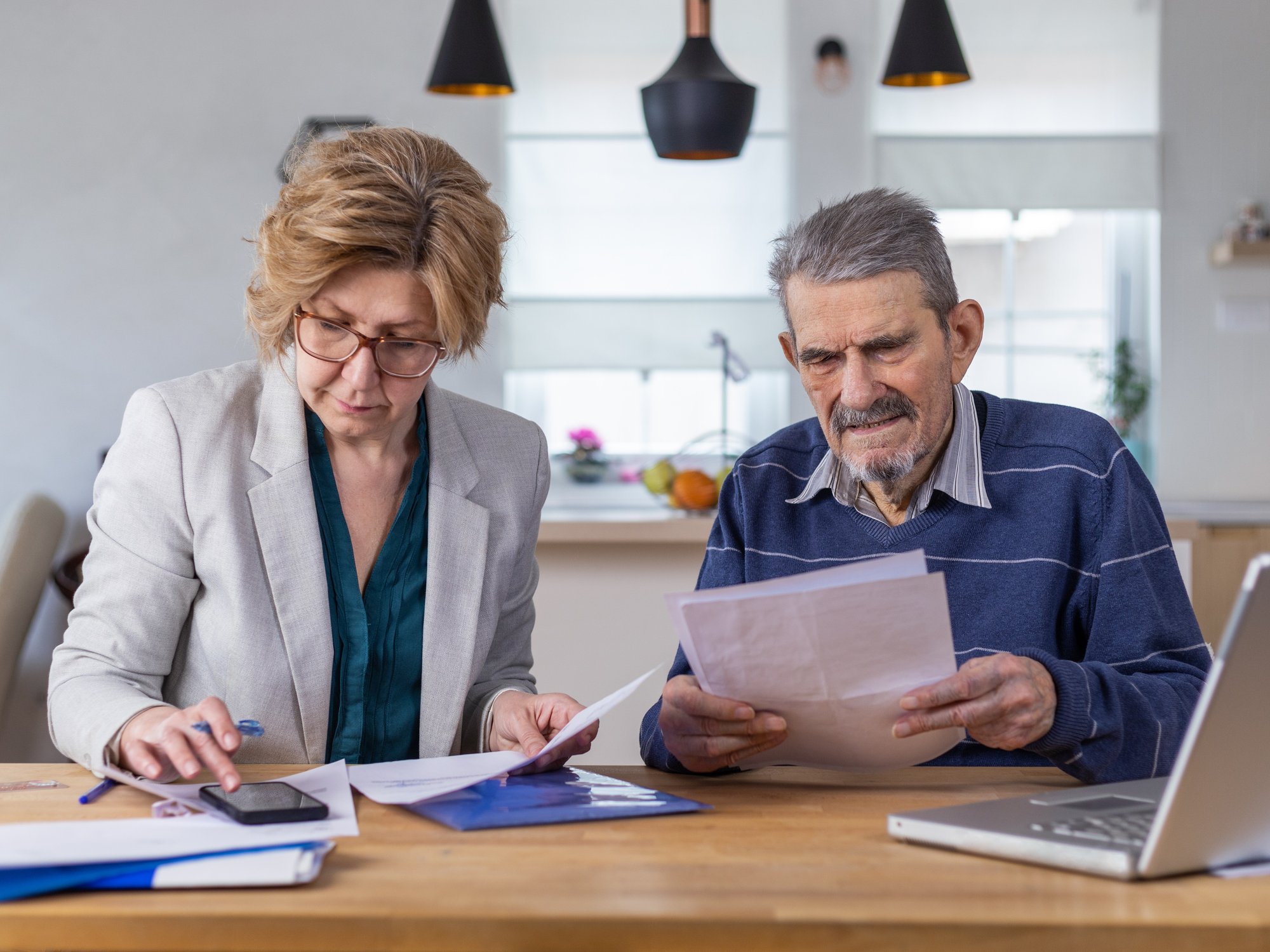 People look at bank statements beside phone and laptop