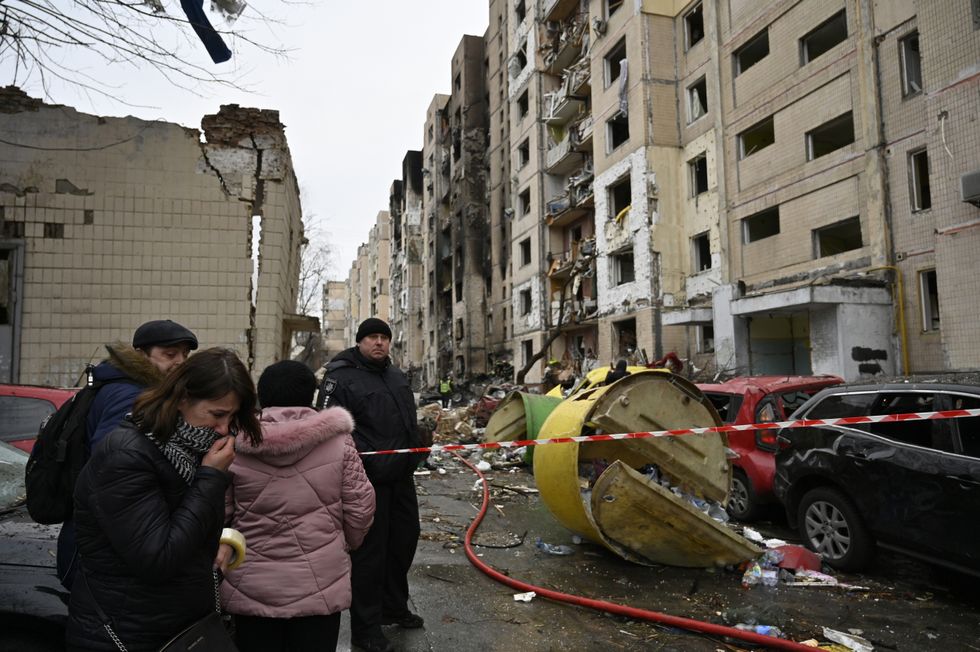 People look at destroyed residential building as a result of a missile attack by the Russian army