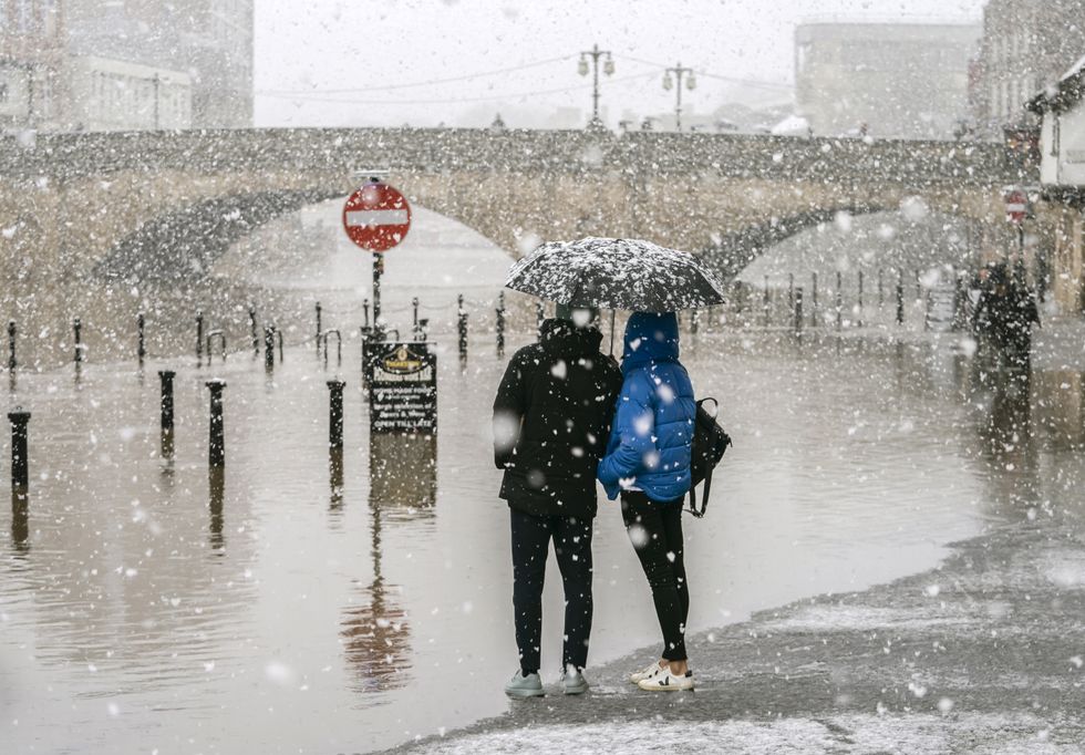People look at flood water in heavy snow in York city centre, Yorkshire, after Storm Eunice brought damage, disruption and record-breaking gusts of wind to the UK and Ireland, leading to the deaths of at least four people. Picture date: Saturday February 19, 2022.