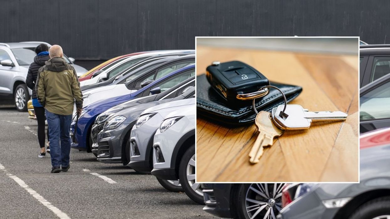People looking at a car dealership and a set of car keys
