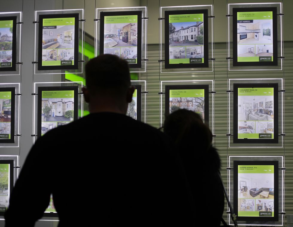 People looking at houses from an estate agent window