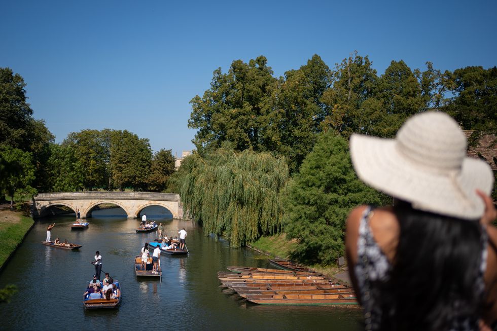 People make the most of the hot weather as they enjoy punt tours along the River Cam in Cambridge.