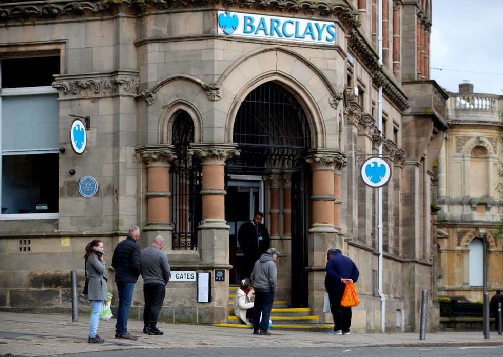 People observe social distancing as they queue outside a branch of Barclays bank in Wolverhampton city centre