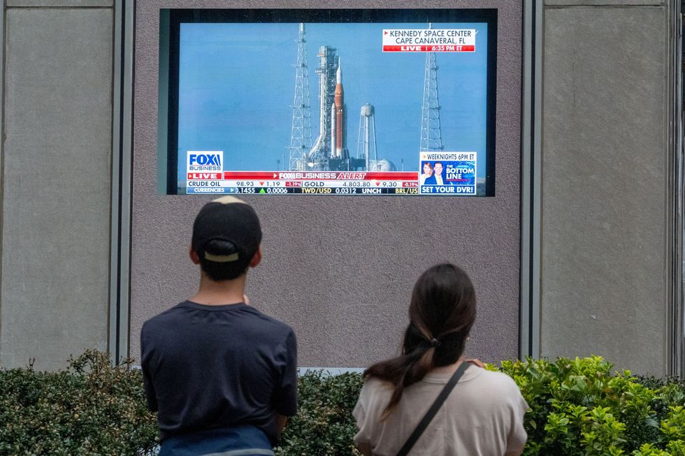 People pause to watch Artemis II