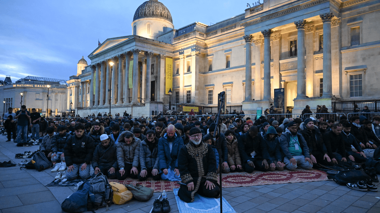 People perform prayers as they attend an 'Open Iftar' event as part of the 'Ramadan Tent Project' in Trafalgar Square