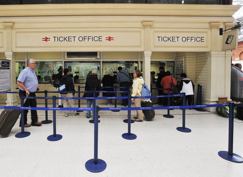 People queue at a rail ticket office