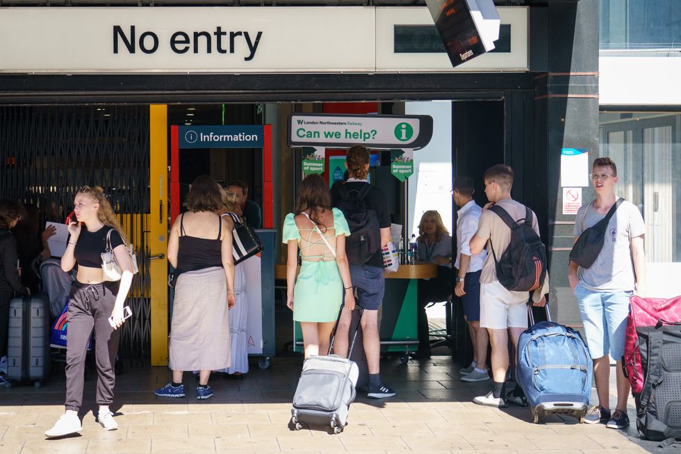 People queue for an information point at a closed entrance to Euston station in London, as members of the drivers union Aslef at nine train operators walk out for 24 hours over pay. Picture date: Saturday August 13, 2022.