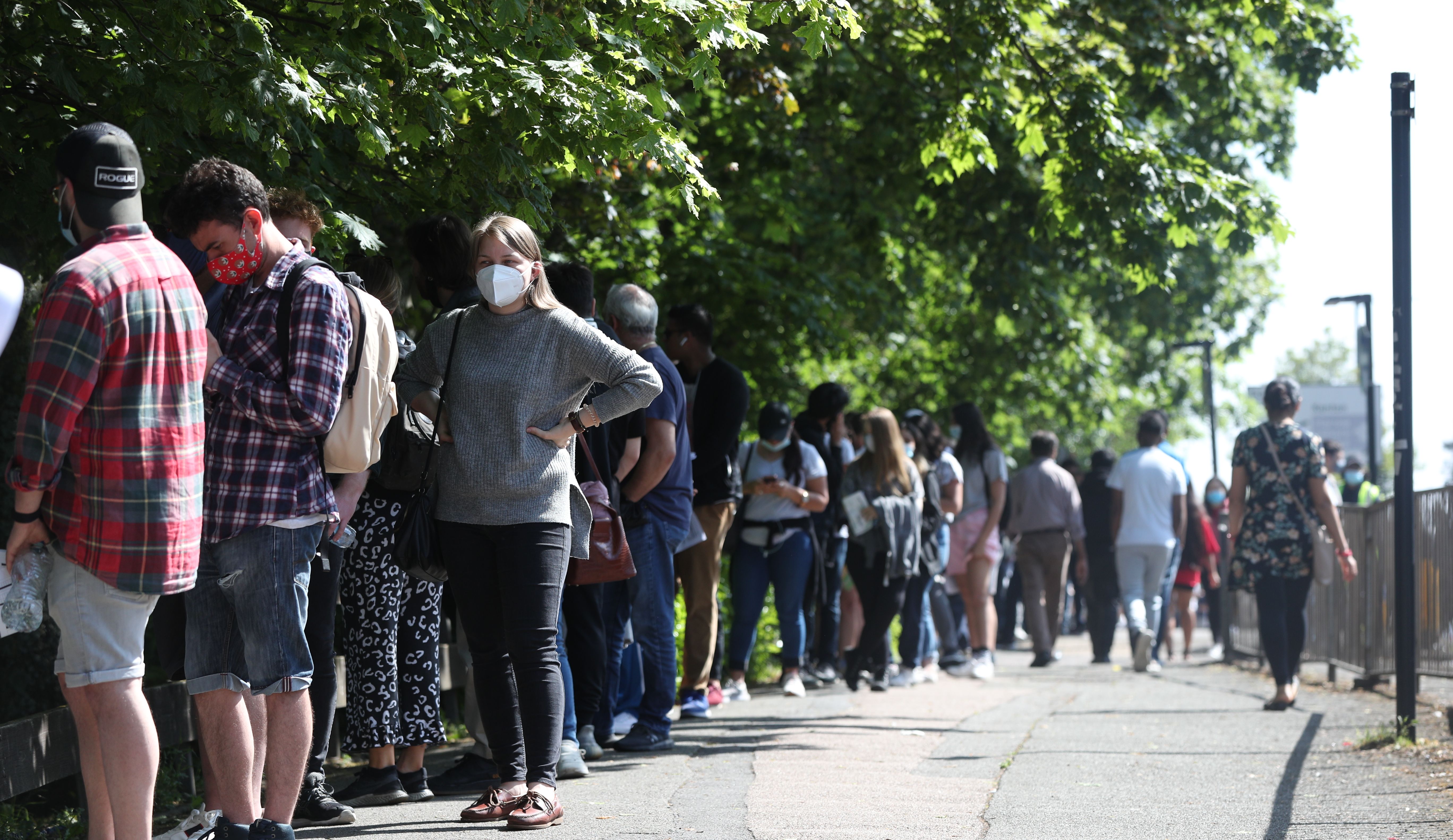 People queuing to go into Belmont Health Centre for their vaccine in Harrow .