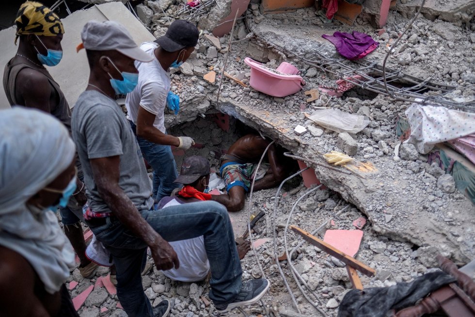 People search for survivors under the rubble of a destroyed hotel after Saturday's 7.2 magnitude quake, in Les Cayes, Haiti August 16, 2021. REUTERS/Ricardo Arduengo