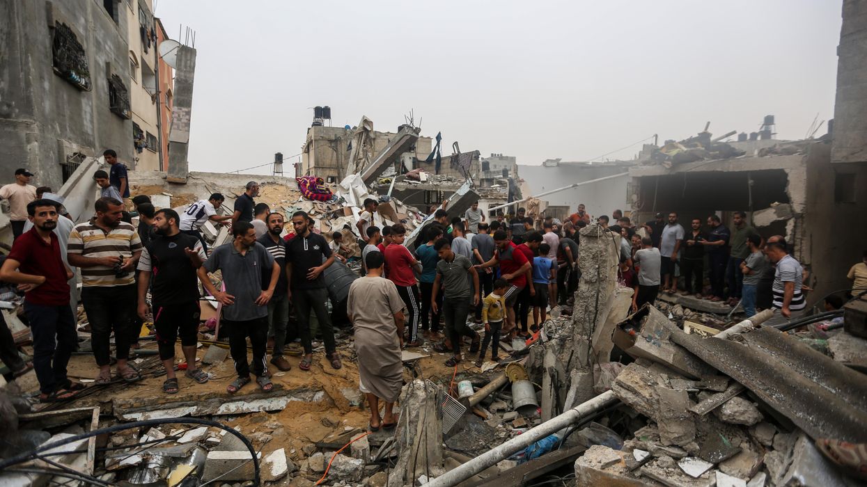 People search through buildings that were destroyed during Israeli air raids in the southern Gaza Strip