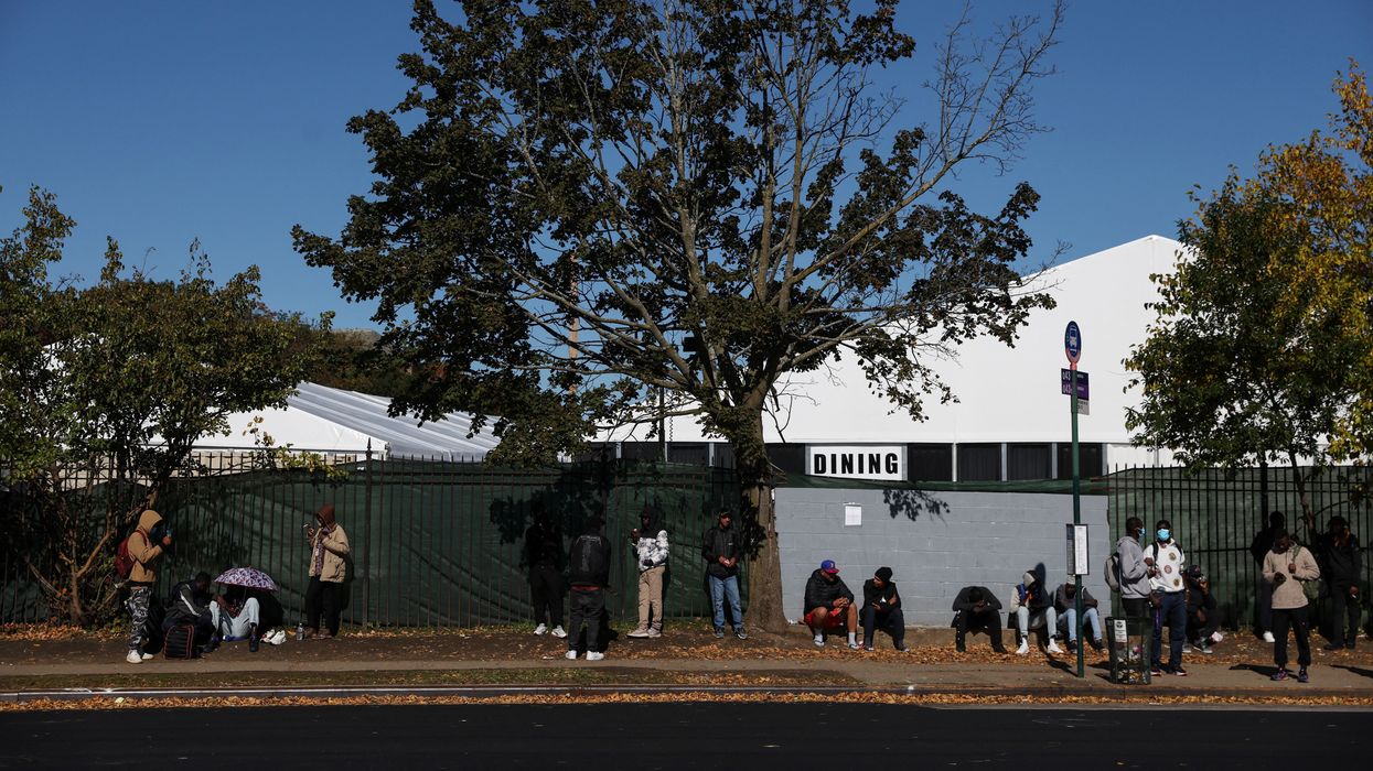 People seeking asylum sit outside a shelter built to house newly arrived migrants on the campus of the Creedmoor Psychiatric Facility in Queens borough of New York City