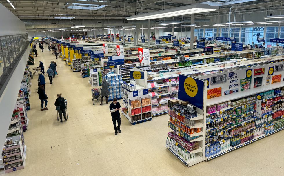 People shop inside a branch of the supermarket retailer Tesco