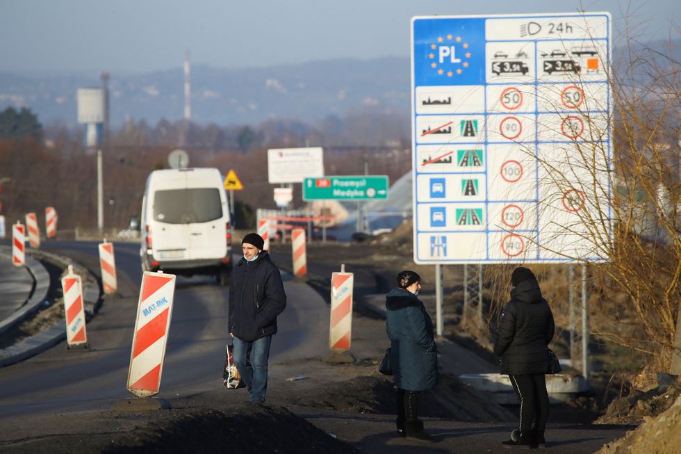 People stand at the border crossing between Poland and Ukraine, after Russian President Vladimir Putin authorised a military operation in eastern Ukraine, in Medyka, Poland, February 24, 2022. REUTERS/Kacper Pempel