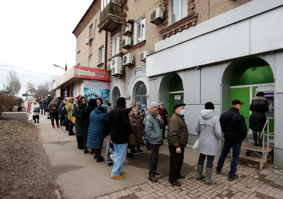 People stand in line to use an ATM money machine, after Russian President Vladimir Putin authorised a military operation in eastern Ukraine, in the separatist-controlled city of Donetsk, Ukraine February 24, 2022. REUTERS/Alexander Ermochenko