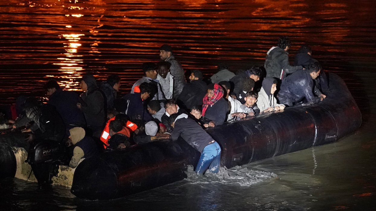 People thought to be migrants successfully launch a small boat from a riverbank in Gravelines, France