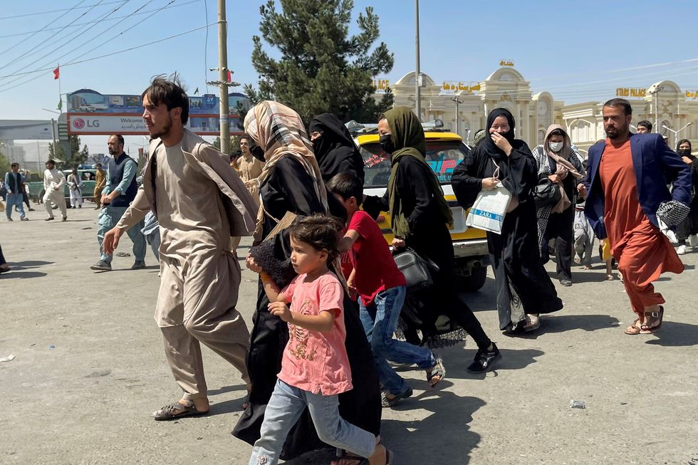 People try to get into Hamid Karzai International Airport in Kabul, Afghanistan August 16, 2021.