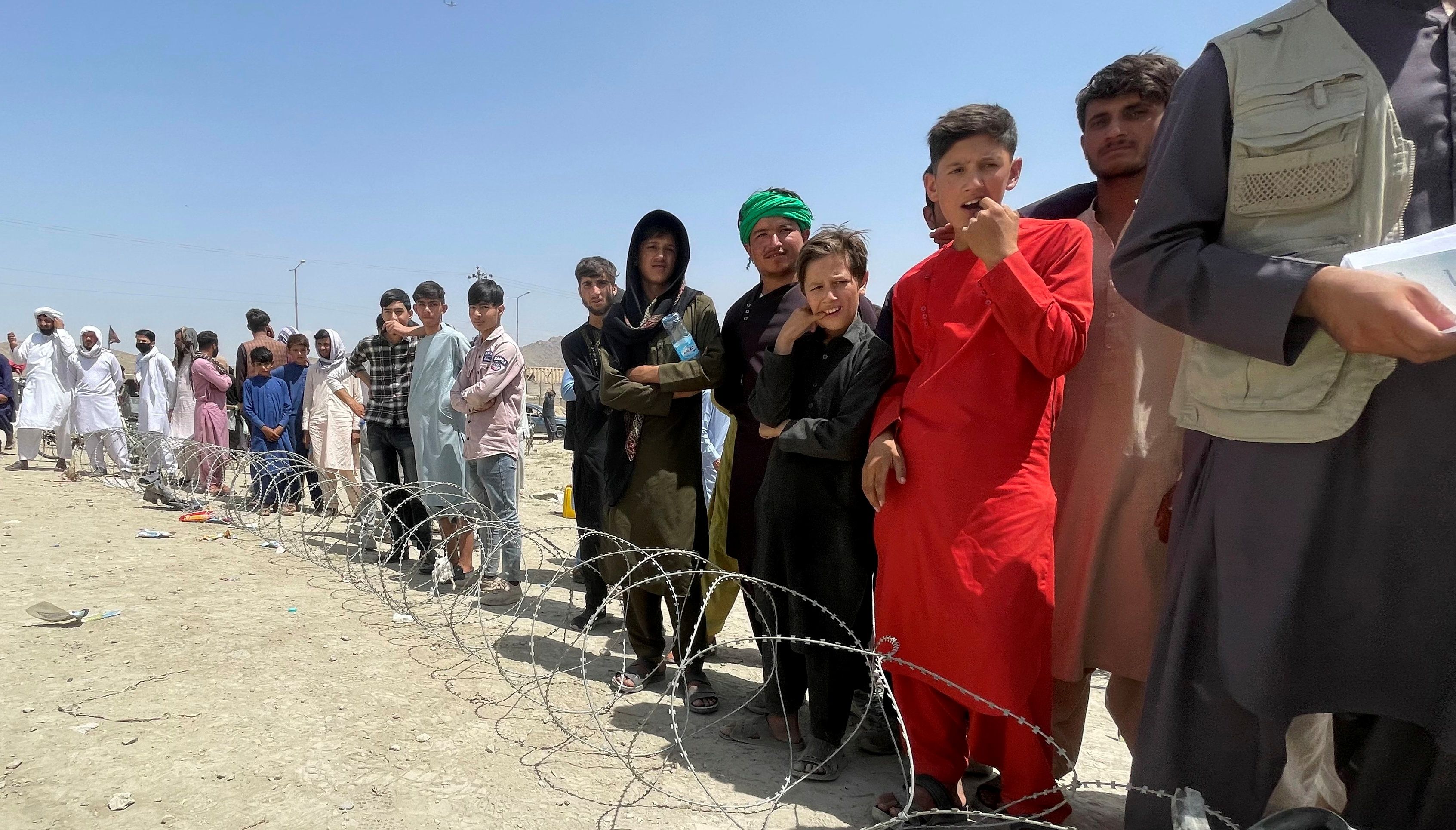 People wait outside Hamid Karzai International Airport in Kabul, Afghanistan August 17, 2021.