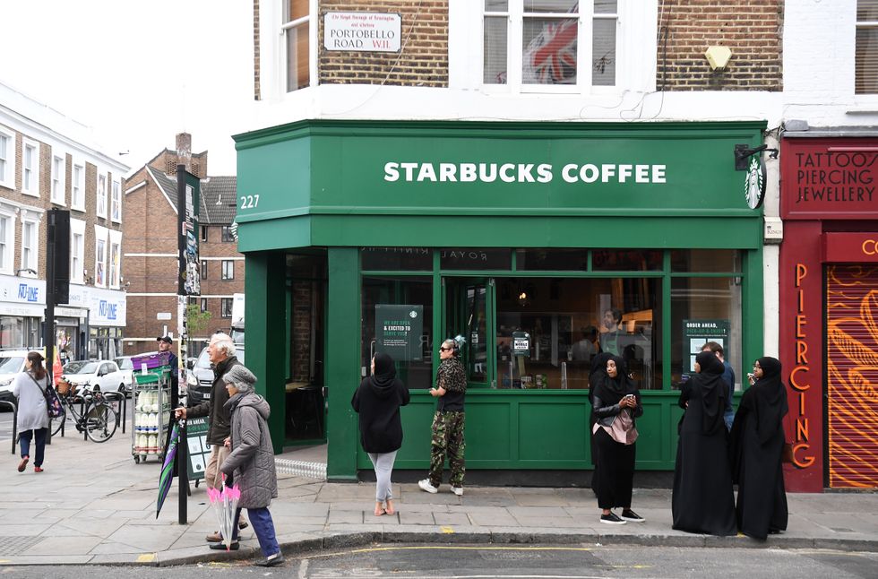 People wait outside Starbucks on Portobello Road in London