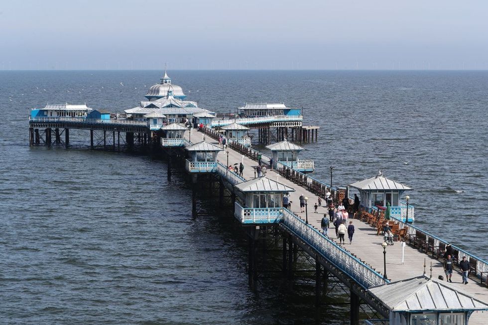People walk along the pier in Llandudno, Wales