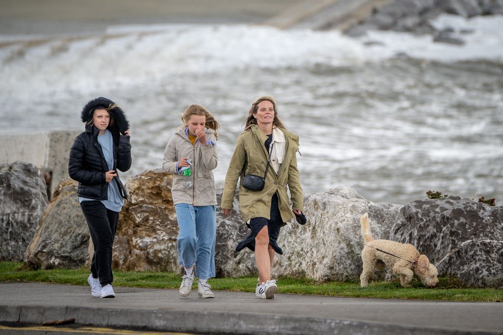 People walk their dog along the sea front in Porthcawl, Wales, after winds of up to 75mph lashed parts of the South West as Storm Evert hit the UK on Thursday and Friday. The Met Office said the newly named storm will bring "unseasonably strong winds and heavy rain". Picture date: Friday July 30, 2021.