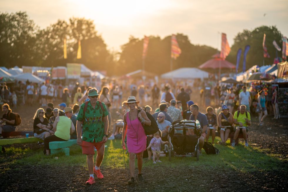 People walk through the market and shopping area at the Glastonbury Festival at Worthy Farm in Somerset